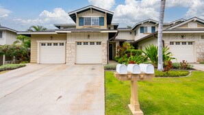 A residential house with a garage, a mailbox, and a well-maintained lawn. - You're Resort Home! Walk to Disney, Beach & Pool! (Kapolei)