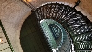 A spiral staircase with a metal railing and a green floor. - Welcome to Saltwater Seaclusion! Heart of Corolla!  Walk to Everything! (Corolla)