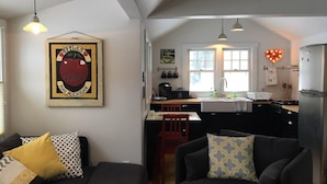 A compact living space with a kitchenette, a dining area, and a seating area with a couch and chairs. - Apartment in the heart of Leland, just a short walk to Fishtown. (Leland)