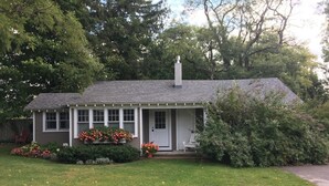 A single-story house with a front porch, a chimney, and a well-maintained lawn. - Apartment in the heart of Leland, just a short walk to Fishtown. (Leland)
