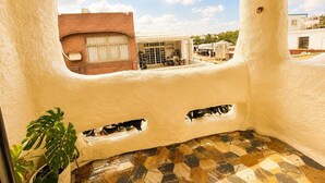 A room with a unique curved ceiling, a view of the outside buildings, and a potted plant. - Dory Hostel  (Liuqiu)