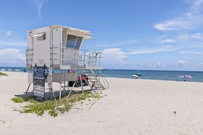 A lifeguard tower on a beach with clear skies.