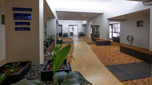 A hotel lobby with a central pathway, guest laundry, and vending area signs. - Essence Apartments Chermside (Brisbane)