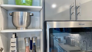 A kitchen with stainless steel appliances, including a refrigerator, a sink, and a colander on the shelf. - Rooftop Hot Tub in Downtown Walnut Creek (Walnut Creek)