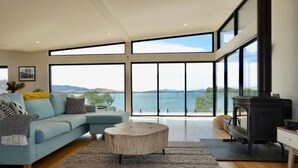 Una sala de estar moderna con un sofá grande, una mesa de centro redonda y una chimenea.