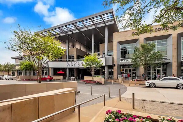 A modern building with a glass facade, outdoor seating, and a sign for 'Cowood'. - Downtown Frisco Gem (Frisco)