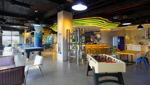 A modern indoor recreational area with a pool table, foosball table, and various seating arrangements. - Tru by Hilton Lang Son City Centre (Dong Kinh)