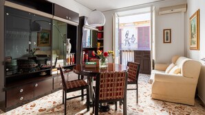 Un comedor con una mesa redonda, sillas y un aparador de vidrio con objetos decorativos.