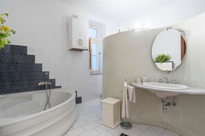 Une salle de bain moderne avec une baignoire sur pieds, un lavabo avec un miroir et un porte-serviettes.