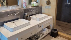 A modern bathroom with two sinks, a large mirror, and a shower area. - Stunning Loft Grand Luxxe (Nuevo Vallarta)