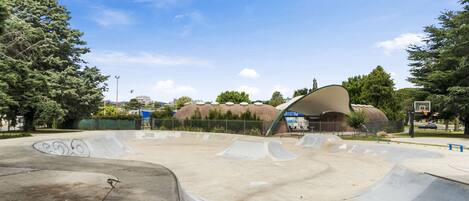 Un parco di skate con diverse rampe e una grande struttura curva al centro.