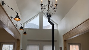 A spacious kitchen with a large island, a black stove, and a chandelier. - The White House- Suite B Upstairs (Silverton)