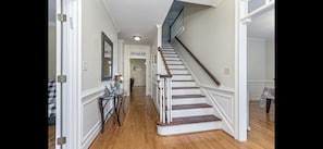 Stunning staircase leads to an upper level, complemented by a glass table and vase of flowers.