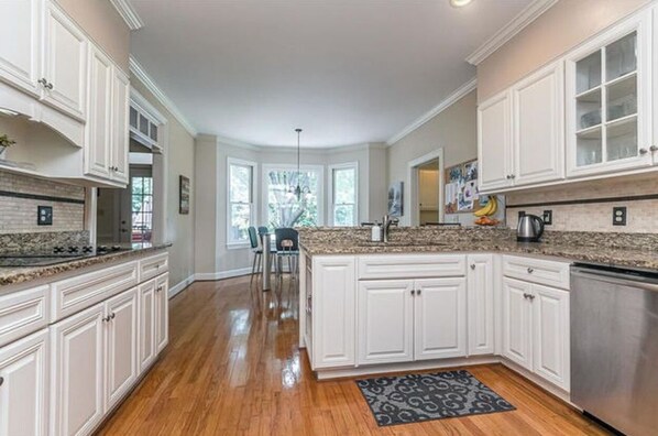 Enjoy meals in the kitchen with a central island, white cabinetry, and a dining area.