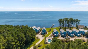 A coastal resort with multiple blue cabins, a swimming pool, and a dock extending into the water. - Neuse Village #3 - Check out the amazing views! (Arapahoe)