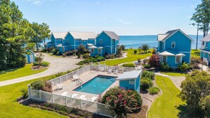 A residential area with multiple blue houses, a swimming pool, and a view of the sea. - Neuse Village #3 - Check out the amazing views! (Arapahoe)