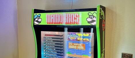 A retro arcade machine with a neon sign above it.