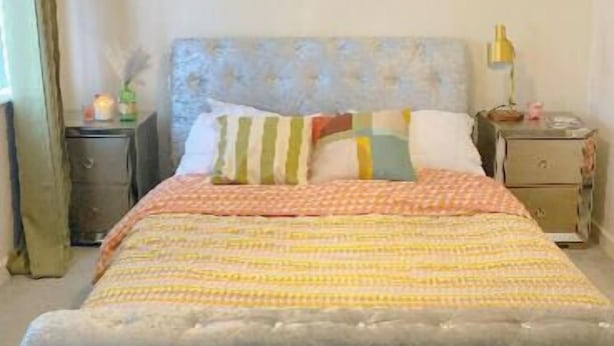 A bedroom with a large bed, a chandelier, and bedside tables. - 2 Bed House - Sleeps 4 - Parking - Wifi (Leeds)