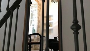 Un escalier avec un plafond en bois et un lustre en arrière-plan.