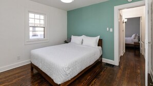 A bedroom with a bed, a window, and a door leading to another room. - Downtown 2 BR Retreat / Discounts for Longer stays (Indianapolis)