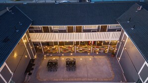 An outdoor patio area with a seating arrangement and string lights. - Gateway Lodge (Seaside)