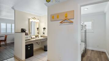 A modern bathroom with a sink, mirror, and towel rack.