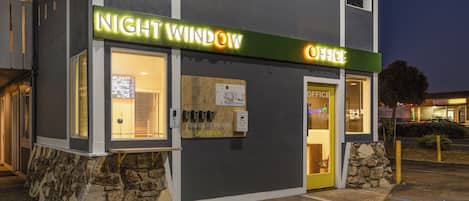 A building with a sign reading "NIGHT WINDOW OFFICE" and a stone base.
