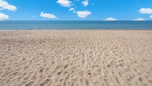 A sandy beach with footprints leading to the water. - Esmeralda Beach Resort 2 Bedrooms Condo B 403 (Puerto Penasco)
