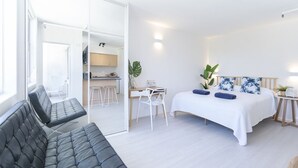 A modern bedroom with a bed, a sofa, a desk, and a chair. - HolidayRento Bondi Rooftop Pool & Air Con Studio (Bondi)