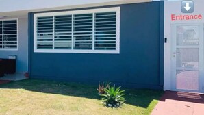 Un edificio con un amplio ventanal y un cartel de entrada.
