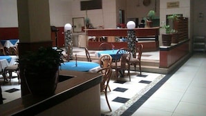 A lobby with a reception desk, seating area, and a tiled floor. - Cicada Hotel (Eldoret)