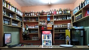 A bar with shelves stocked with various liquor bottles, a refrigerator, and a computer monitor. - Sizzling Waters Resort (Nakuru)