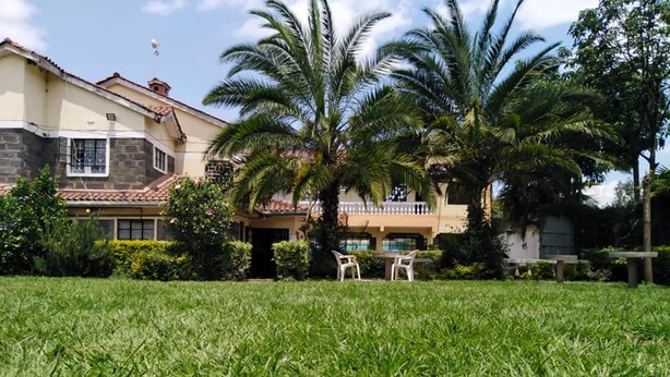 A two-story house with a well-maintained lawn and a pool area. - Sizzling Waters Resort (Nakuru)