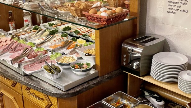 A buffet with various food options including meats, salads, and eggs.