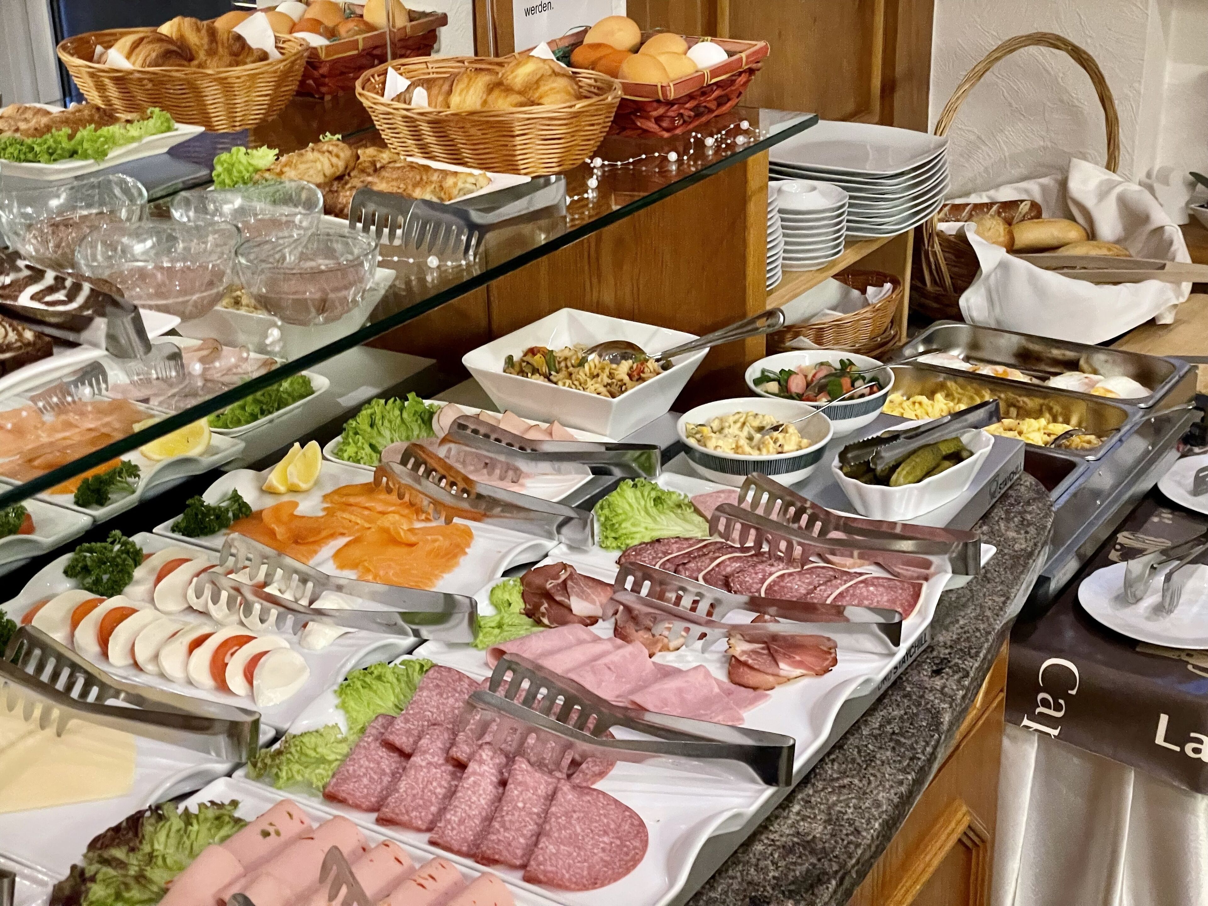 A buffet with various food items including meats, salads, and pastries.