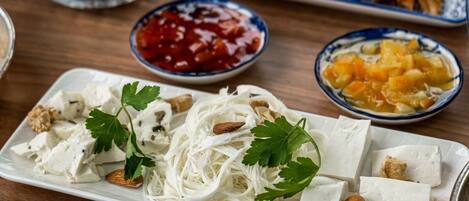 Una mesa con diversos platos, entre ellos fideos, tofu y rollos primavera.