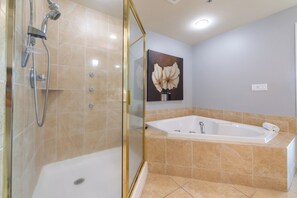 Een bad/douchecombinatie, een bubbelbad, een haardroger, handdoeken