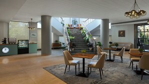 A spacious lobby with a staircase, seating area, and a reception desk. - The Fern Residency Navi Mumbai, Turbhe, Series by Marriott (Navi Mumbai)