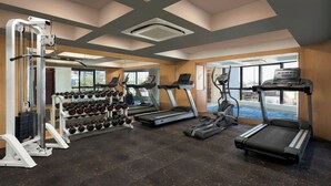 A gym with treadmills, a weight machine, and dumbbells. - The Fern Residency Navi Mumbai, Turbhe, Series by Marriott (Navi Mumbai)