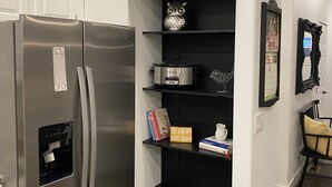 Una cucina con dispensa integrata, frigorifero in acciaio inossidabile e dispenser di acqua.