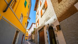 Una calle estrecha flanqueada por edificios con diversos estilos arquitectónicos y un camino adoquinado.