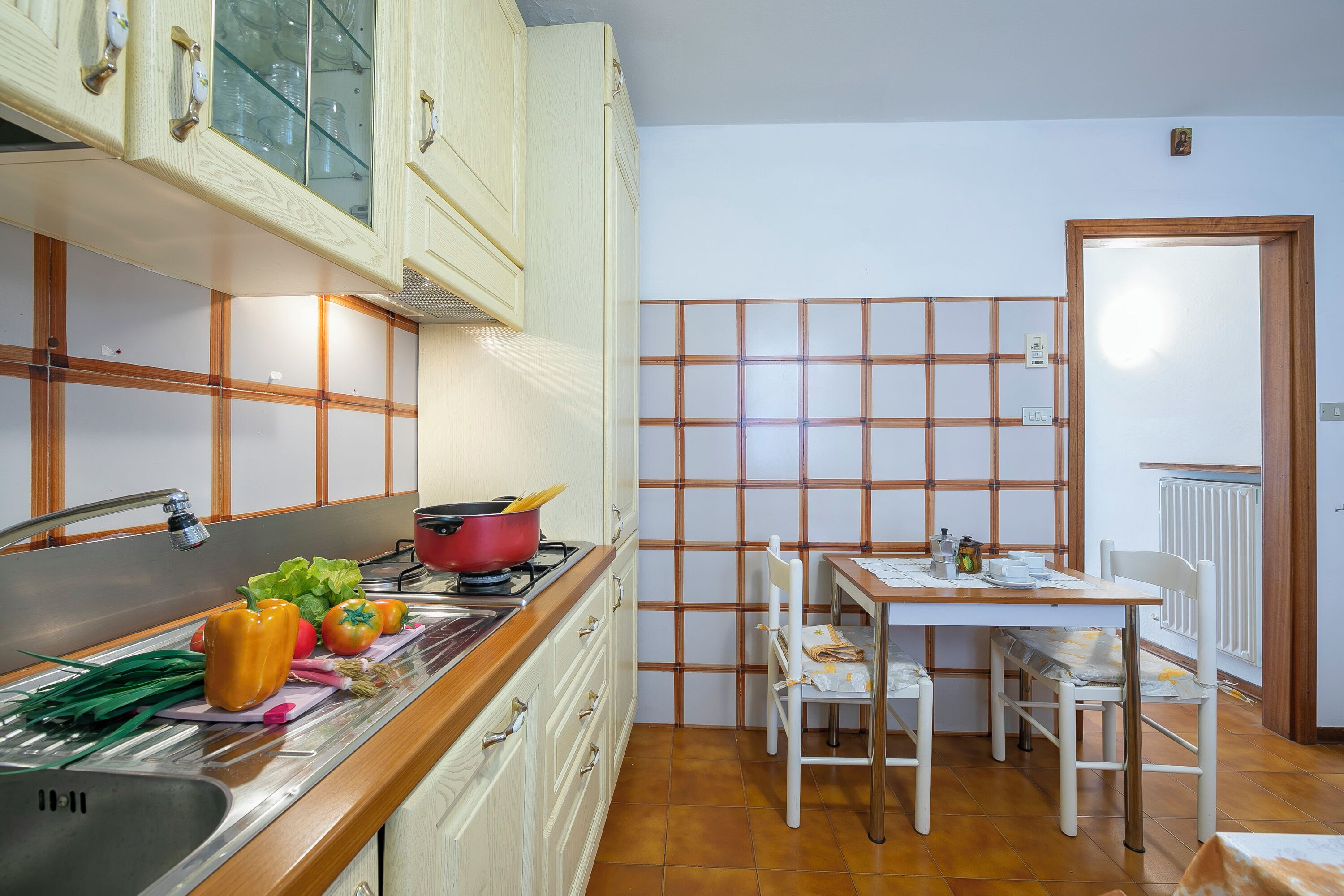 Une cuisine compacte dotée d’un plan de travail en bois, d’une cuisinière et d’un coin repas avec une table et des chaises.