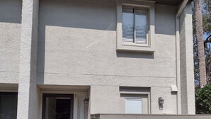 A two-story building with a front door, a small window, and a garage door. - Surf Court Unit #1-Remodeled villa across the street from the ocean (Hilton Head Island)