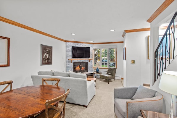 A living room with a fireplace, a dining table, and two sofas.