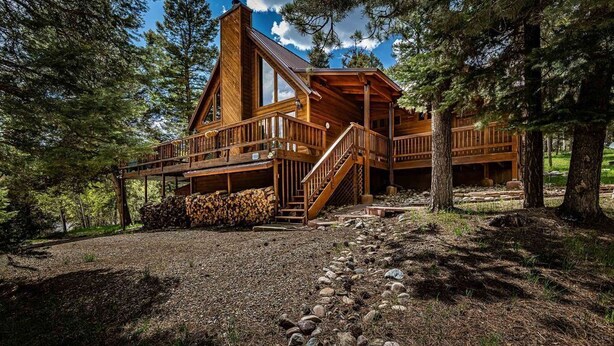 Eine Holzhütte mit Veranda, Treppe und Holzstapel.