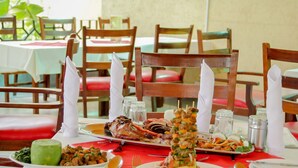 A dining table with a variety of dishes, including seafood and vegetables, set with white napkins and salt and pepper shakers.