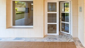 A building entrance with a glass door, a tiled floor, and a sign indicating 'PORTAL 4'. - Modern Apartment 'In Jardin Botanico' with Sea View, Pool, Wi-Fi, Garden & Terrace (La Cala de Mijas)