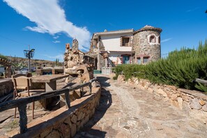 Un bâtiment en pierre doté d’une tour, d’un chemin pavé et d’une clôture en bois.