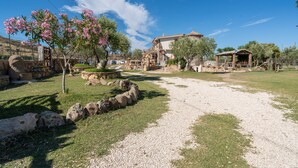 An outdoor area with a stone pathway, a gazebo, and a building with a tiled roof. - Studio 'Sa Burrida' Relax close to the Sea with Garden & Wi-Fi (Posada)