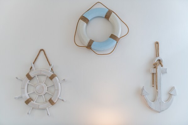 Decoración náutica con timón, boya salvavidas y ancla.